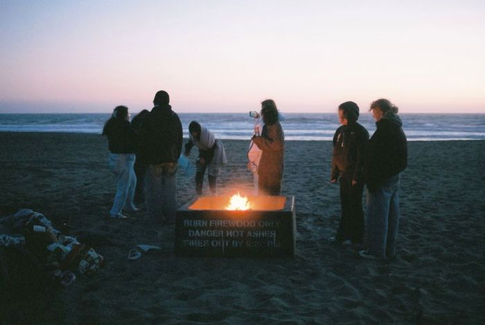 Friends around a fire on the beach